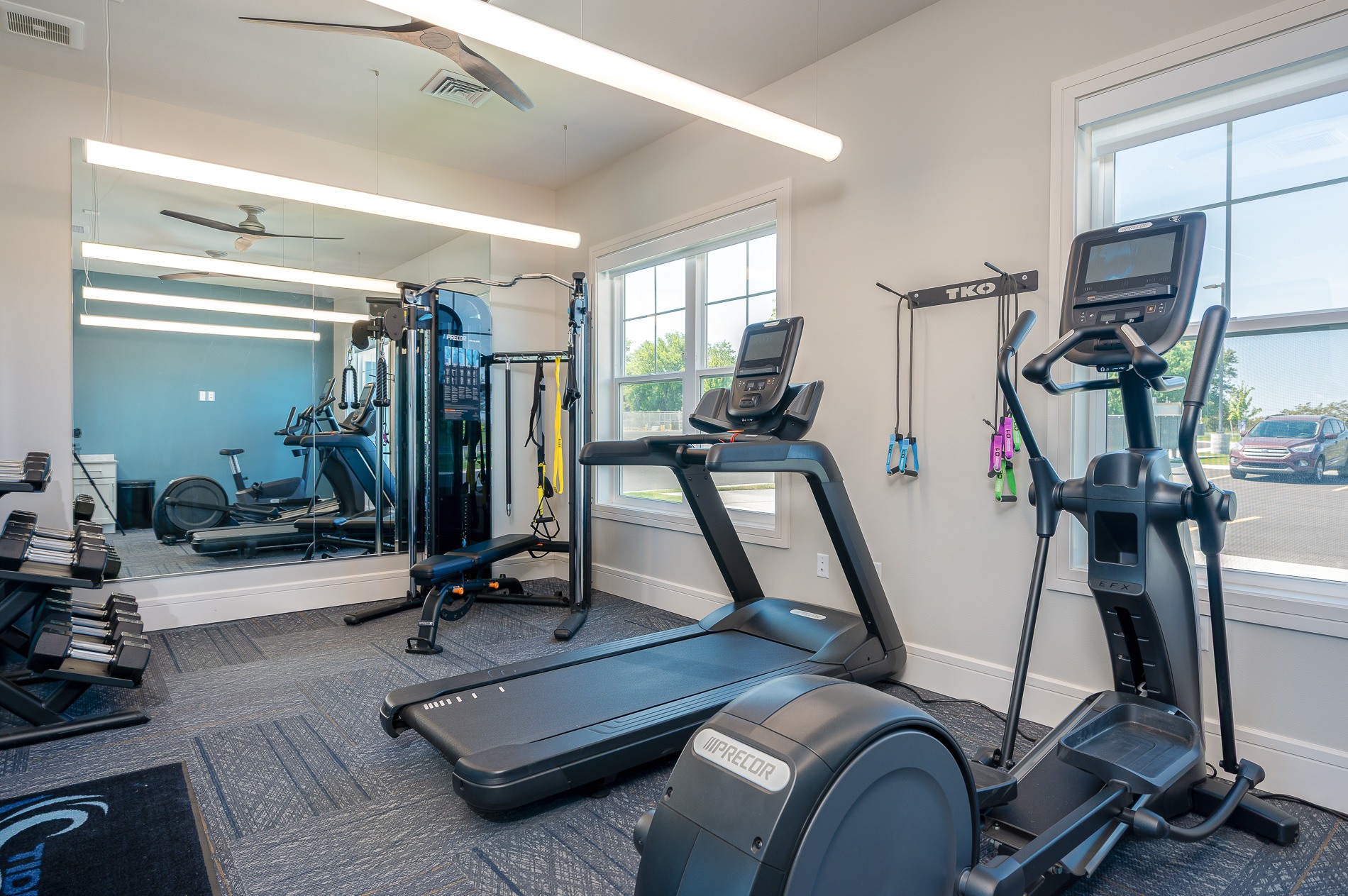 A gym with treadmills, elliptical machines, and other exercise equipment.